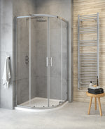 A modern two door quadrant shower enclosure with clear glass and chrome handles, installed in a bathroom setting.